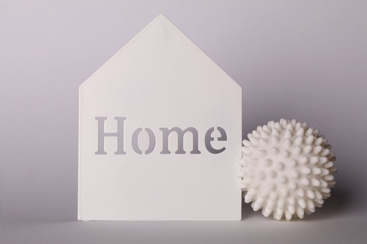 Stylish minimalistic home decor featuring a symbolic house silhouette and spiky ball on a neutral background.